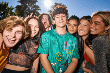 a group of young people posing for a picture with one wearing a green shirt with a smiley face on the front