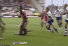 a group of men are playing a game of rugby on a field