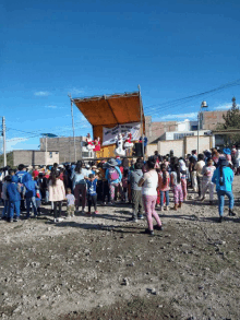 a large group of people are gathered in front of a stage with a sign that says " feliz navidad " on it