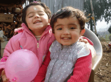 two little girls are posing for a picture and one has a sticker on her face that says " i love you "