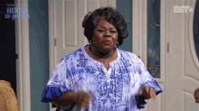 a woman in a blue and white shirt is standing in front of a door that says " house of poverty "