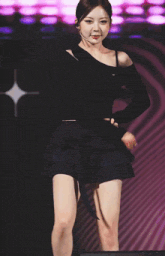 a woman in a black crop top and a black skirt