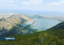 a large lake surrounded by mountains and trees with the words lexpress.mu in the corner