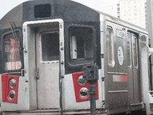 a subway train with the doors open is parked next to a pole .