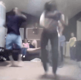 a group of people are dancing in a living room while a man holds a baby .