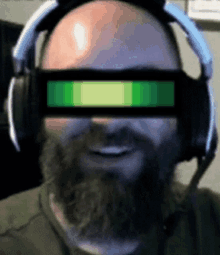 a bald man with a beard wearing headphones and glasses