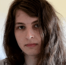 a young woman with long hair looks at the camera