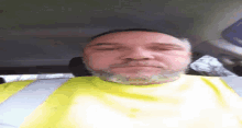 a man with a beard is wearing a yellow safety vest .