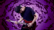 a man is playing an electric guitar in front of a purple background with bats