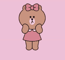 a brown bear wearing a pink dress with a bow