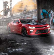 a red chevrolet camaro is parked in front of a building