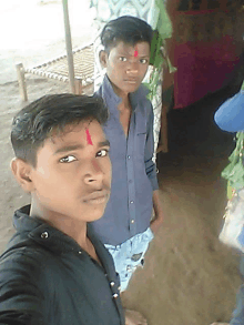 a boy with a red dot on his forehead poses for a photo