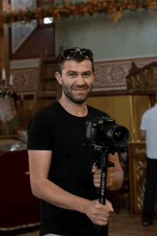 a man holding a camera and a tripod that says glidecam hd