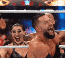 a man and a woman are standing in a wrestling ring with their mouths wide open