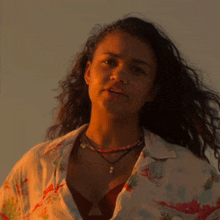 a close up of a woman wearing a floral shirt