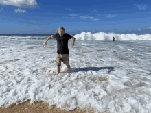 a man in a black shirt is standing in the water