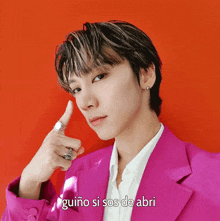 a young man in a pink suit is making a peace sign in front of a red background that says guiño si sos de abri