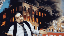 a man stands in front of a burning building and a sign that says ' atlanta '