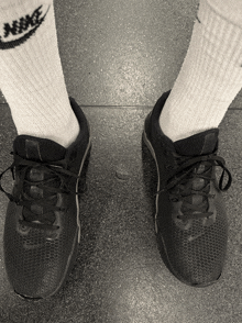 a person wearing a pair of nike socks and black shoes