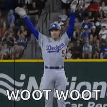 a dodgers baseball player is standing on the field with his arms in the air and the words woot woot behind him .