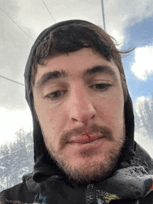 a close up of a man 's face with a hood on his head