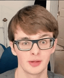 a close up of a young man wearing glasses .