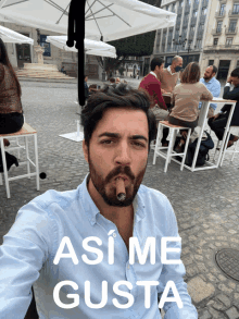 a man smoking a cigar with the words " asi me gusta " above him