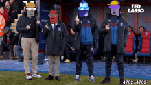 a group of men standing next to each other on a soccer field giving the middle finger .