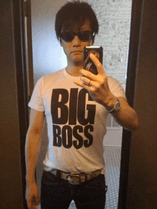 a man taking a picture of himself in a mirror wearing a shirt that says big boss