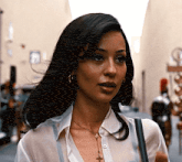 a woman wearing a cross necklace and earrings