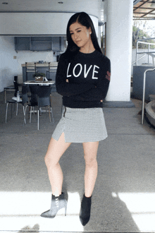 a woman wearing a sweater that says love