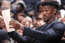 a man in a suit is holding a piece of paper in front of a crowd with the words " ignite files " below him