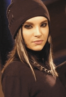 a woman wearing a black beanie and a black turtleneck .