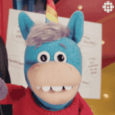 a stuffed animal with a unicorn horn and a red sweater