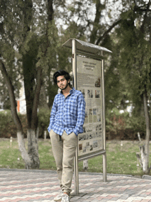 a man in a blue plaid shirt leans against a sign that says ' russian '