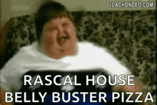 a very fat man is sitting on a couch eating pizza .