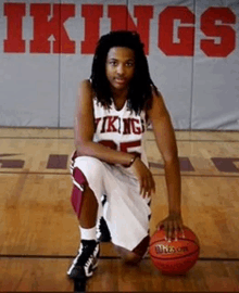 a vikings basketball player kneels on the court