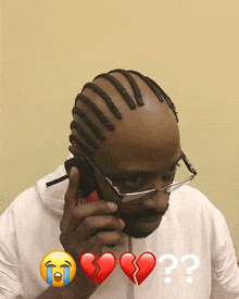 a man wearing glasses is talking on a cell phone with a broken heart in front of him and a question mark