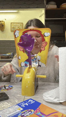 a woman is playing a game called pie face with whipped cream pouring on her face