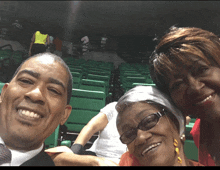 a man and two women are posing for a picture in an empty stadium