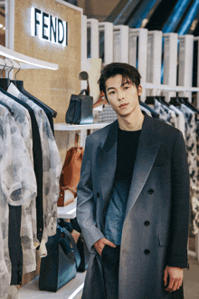 a man is standing in front of a fendi sign