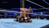 two men are wrestling in a wrestling ring with a sign that says multiple sclerosis association of america