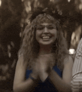 a woman wearing glasses and a wreath on her head is laughing