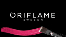 the oriflame logo is on a black background with a brush and pink paint .