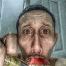 a man is drinking a soda from a can with his mouth open .