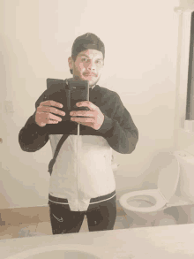 a man is taking a picture of himself in a bathroom mirror