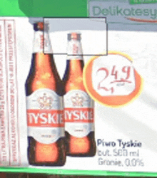 two bottles of tyskie beer are sitting on a table