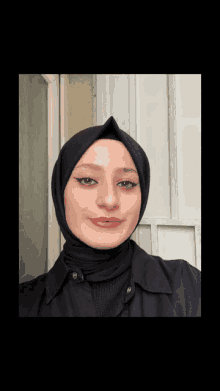 a woman is wearing a black hijab and a black shirt