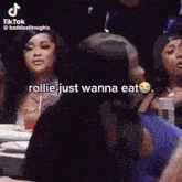 a group of women are sitting at a table and one of them is talking to the other .