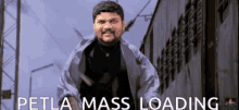 a man with a beard is standing in front of a building with the words petla mass loading behind him